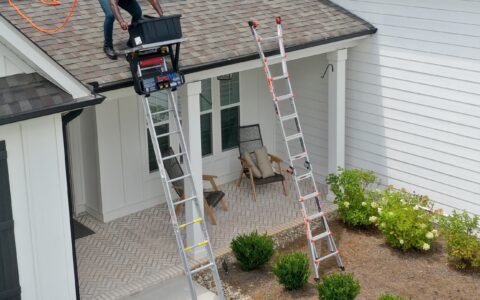TranzVolt Laddervador Collapsible Roofing Platform with man lifting tools to the roof using the Tranzvolt